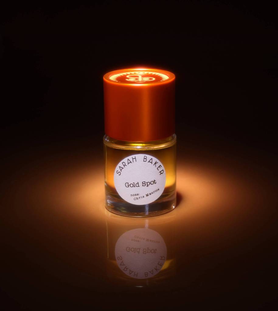 Gold Spot by Sarah Baker: a clear bottle with a red, metallic cap, shown in a golden spotlight